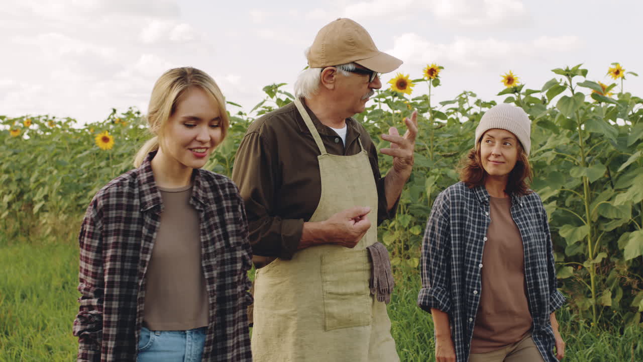 Senior Farmer Talking To Young Women In Field