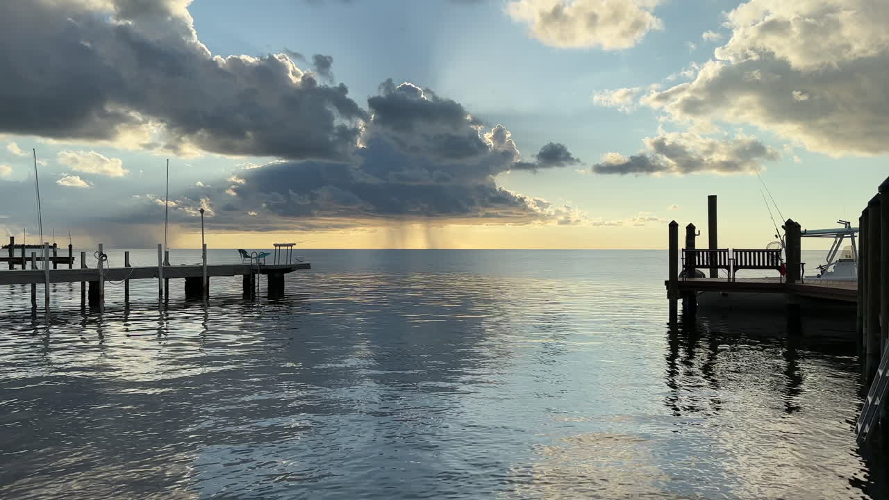Rain storm on sunny cloudy day, view from ocean pier, Florida Keys