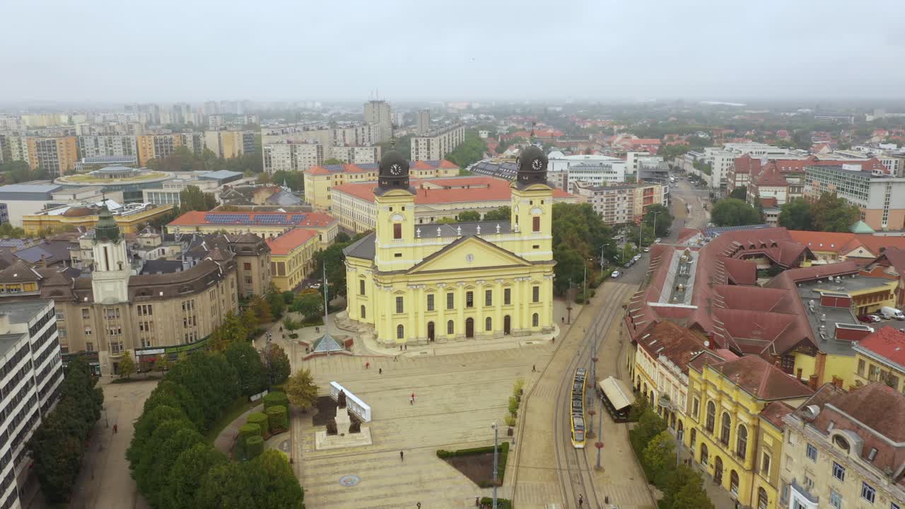 imágenes de drones de la iglesia en la plaza principal de la ciudad de debrecen en clima lluvioso drone de otoño vuela hacia atrás