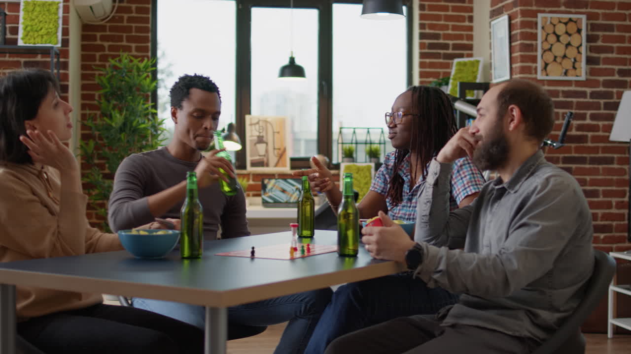 Happy friends enjoying charades board game at home gathering