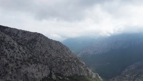 AERIAL---Epic-shot-over-the-ancient-walls-of-Termessos,-Turkey,-forward-spinning-shot