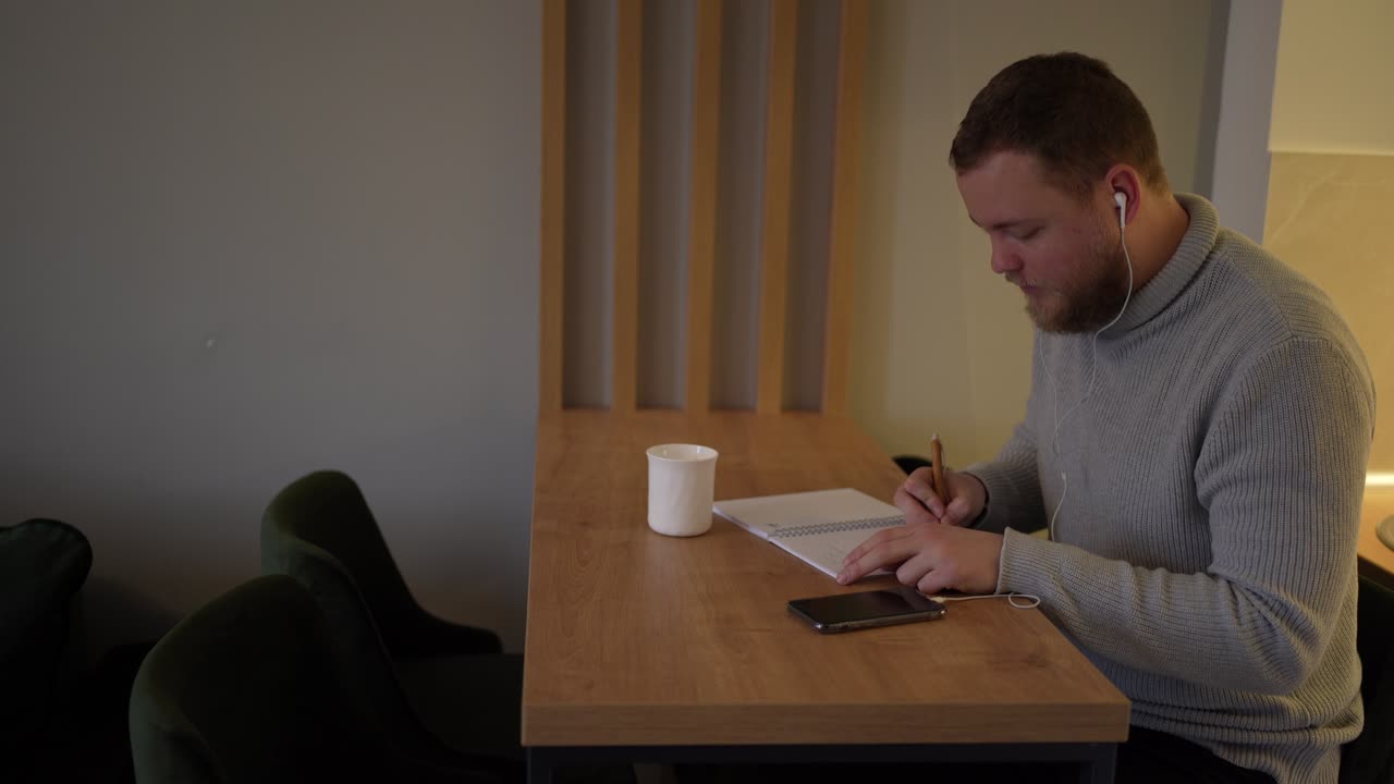 joven influyente masculino escuchando música y trabajando