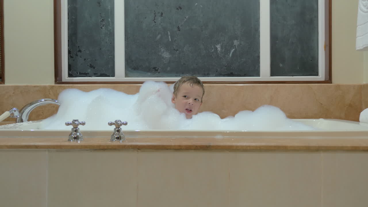 Playful child having bath with foam
