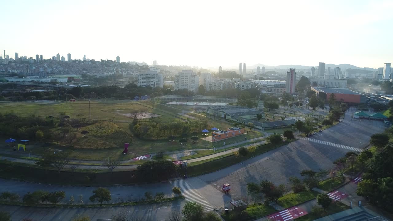 Drone filming at sunset against light in public park full of lush vegetation, tranquility, nature, calm, peace, in 4K resolution