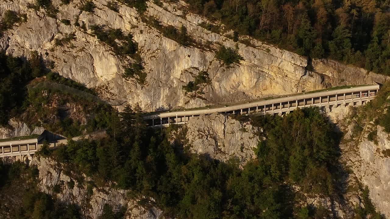 Path in the alpine mountains leading to Lake Walensee and the villages of Wessen and Amden. People driving in cars to visit tourist destinations. Aerial view