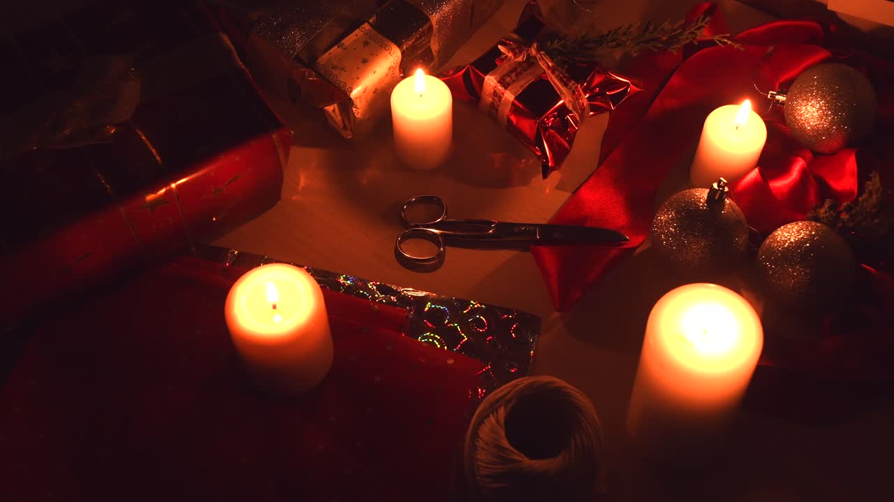 Christmas background with candles, gifts and wrapping equipment