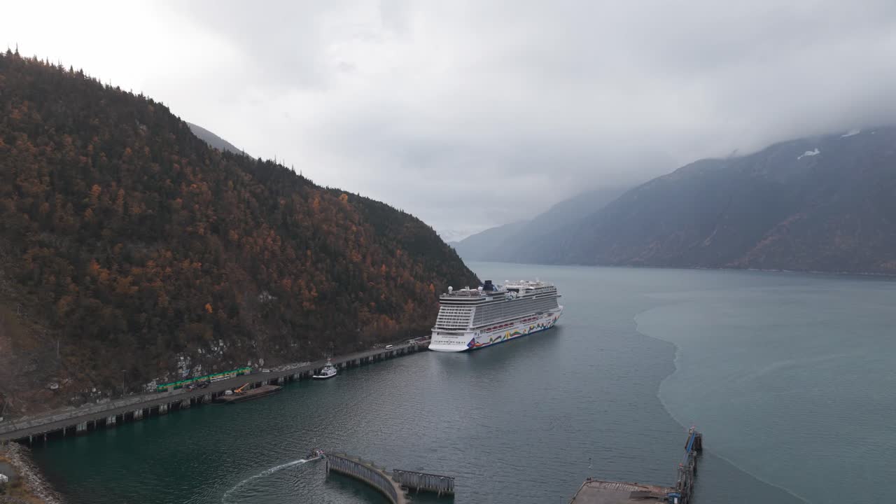 Wide panning aerial shot of the Skagway port with a cruise ship during the fall season in Southeast Alaska. 4K
