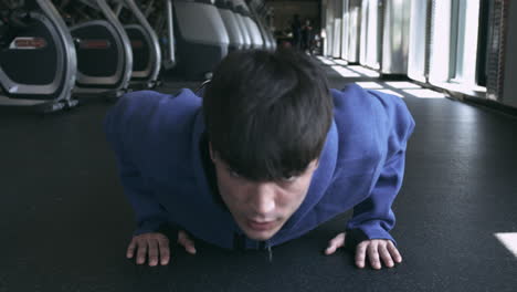 Toma-Directa-De-Un-Hombre-Milenario-Haciendo-Flexiones-En-El-Piso-Del-Gimnasio-Toma-Estabilizada-En-Uhd-4k