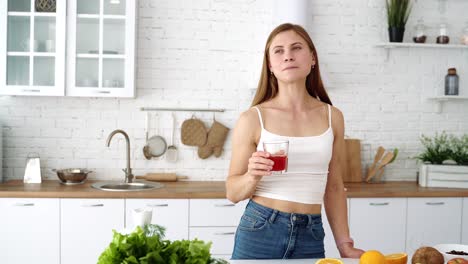 girl in the kitchen drinks fresh fruit juice. table with fruits and vegetables for a healthy diet