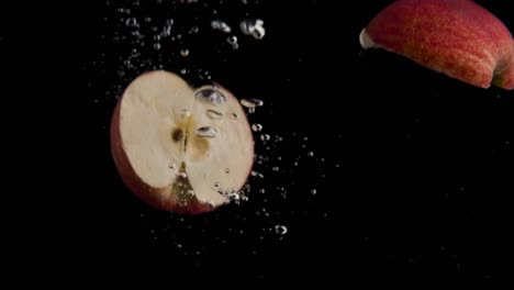 manzana cayendo al agua en cámara superlenta, fondo negro, muchas burbujas de aire, 4k240fps