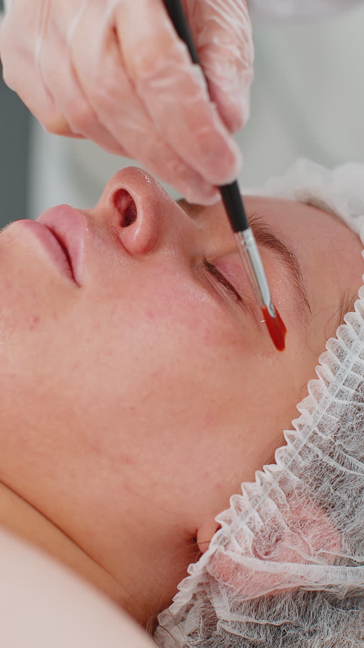 Close up of a woman's face getting her eyelashes and eyebrows done at a beauty salon