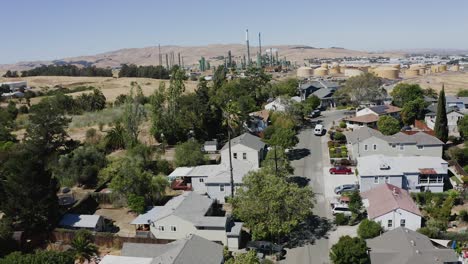 Aerial-view-over-a-suburban-homes,-towards-a-industrial-area,-in-sunny-Oakland,-USA---rising,-drone-shot