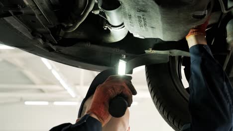 mecánico trabajando debajo de un coche