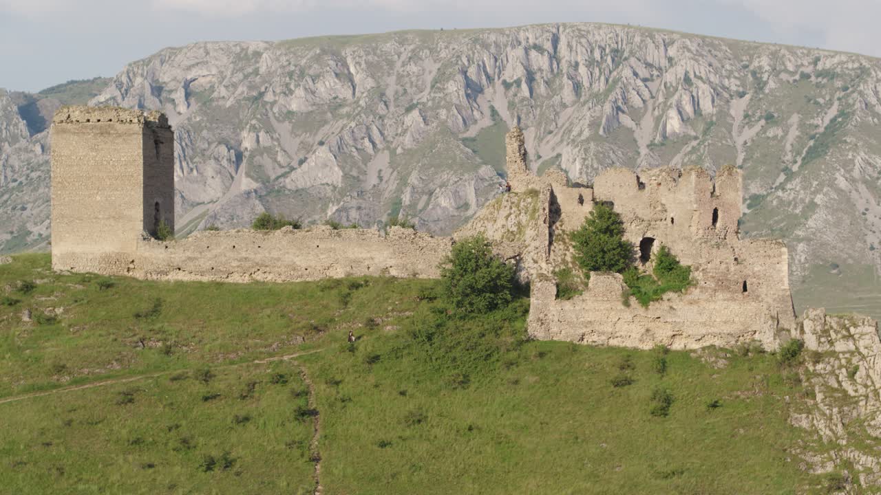 Cinematic drone shot slowly ascending to reveal the medieval Trascău Fortress ruins in Colțești, Romania. An epic historical landmark in the mountains of Transylvania