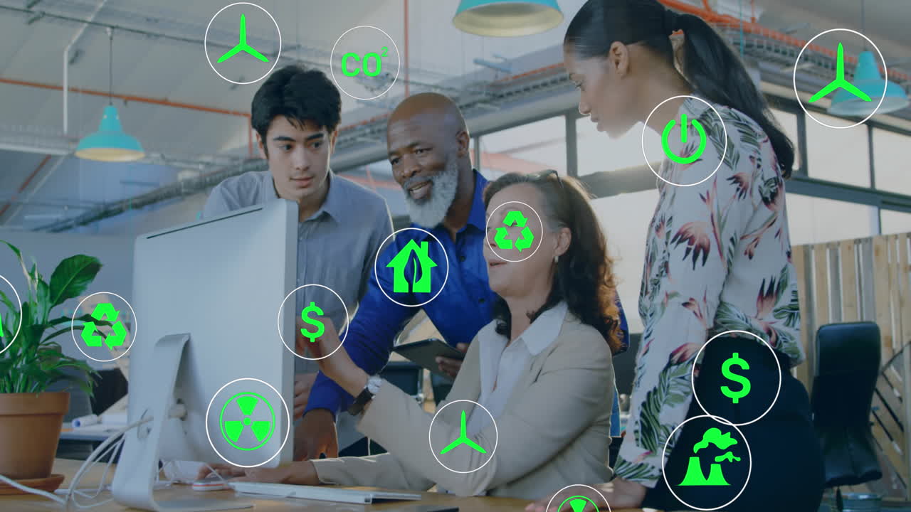 Animation of digital icons over diverse team of collegues discussing over a computer at office
