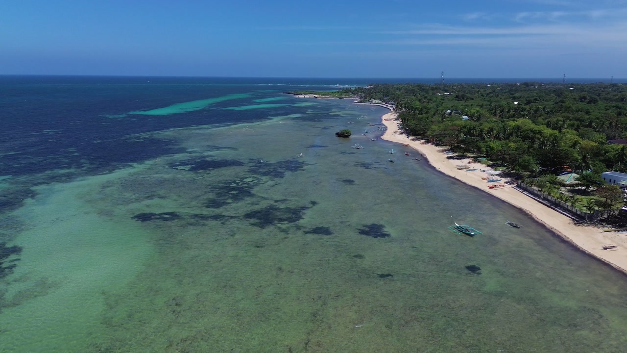 Wide aerial view of Bantayan Island showing an expansive tropical coastline with beaches greenery and surrounding ocean creating a scenic island landscape in the Philippines Southeast Asia