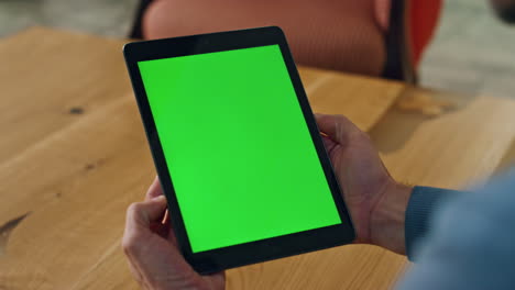hombre viendo la tableta chromakey en la mesa de primer plano. abogado anónimo leyendo correo electrónico