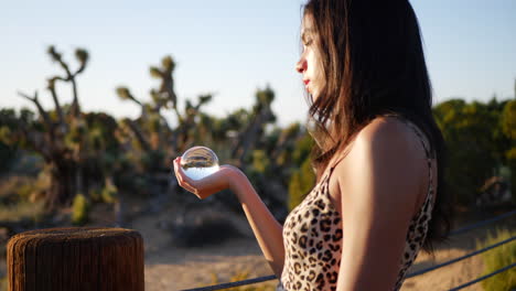 an attractive hispanic woman in a fantasy land holding a magic crystal ball casting a spell or enchantment slow motion