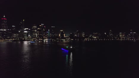 Vista-De-Drones-De-La-Ciudad-De-Perth-En-La-Noche-Con-Barco-Fluvial