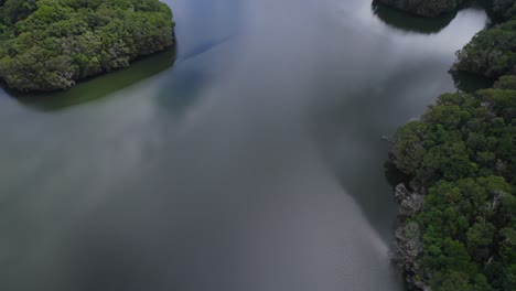 Vuelo-De-Drones-Sobre-La-Presa-De-Cobre-Con-Cielo-Nublado-Reflejado-En-El-Agua-En-Cairns,-Norte-De-Queensland,-Australia