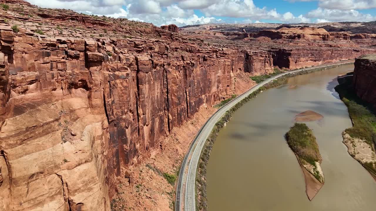 High angle View of Road next to Red Steep Cliffs and River, Potash Road in Moab Utah, train tracks, Colorado River, Lower Colorado Scenic Byway, Close up