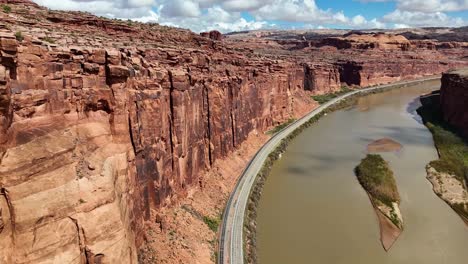 high angle view of road next to red steep cliffs and river, potash road in moab utah, train tracks, colorado river, lower colorado scenic byway, close up
