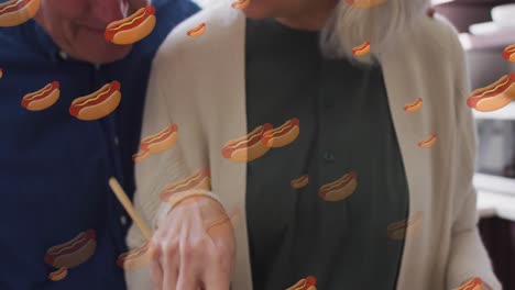 animación de iconos de perritos calientes con una pareja caucásica de alto nivel cocinando