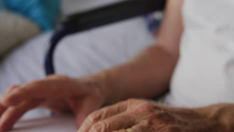 hombre mayor en distanciamiento social leyendo un libro de braille