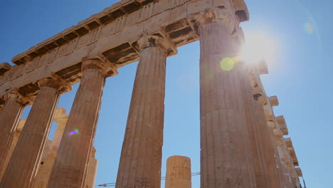 pan de ángulo bajo de las columnas de la acrópolis y el partenón en la cima de una colina en atenas grecia