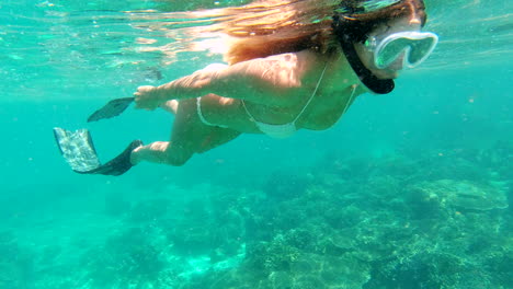 woman snorkeling in a tropical coral reef