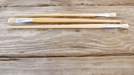 Various-paint-brushes-on-wooden-table