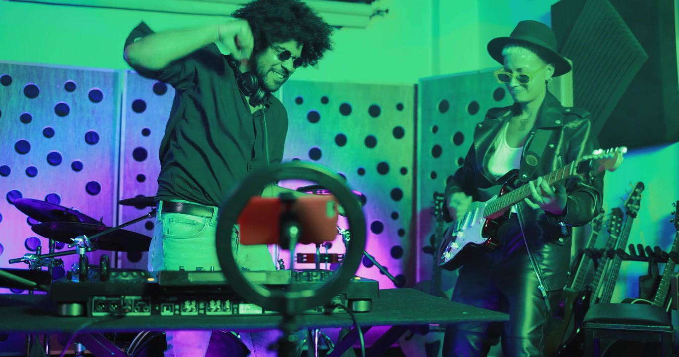 Energetic DJ and Guitarist Performing in a Colorful Music Studio