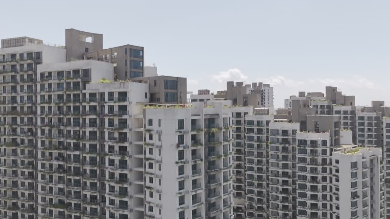 Aerial reveal of Forest City as the drone ascends in front of the Ataraxia towers with Cerulean Tower and Singapore in the distance captured in dlog m color profile