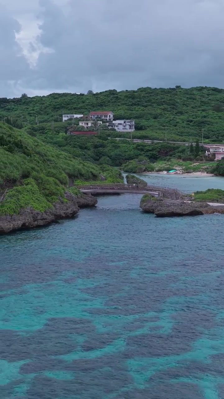 Vista aerea a rotazione rapida del Ponte Imgya e del Giardino Marino Imgya in una giornata nuvolosa, Isola di Miyako, Okinawa, Giappone.