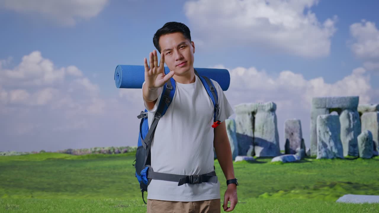 Man with Backpack Stopping Gesture at Stonehenge