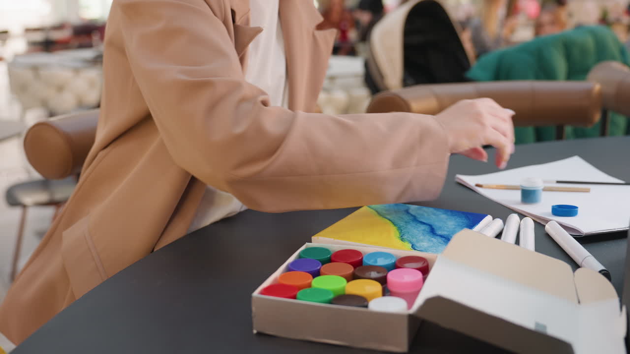 mujer organizando con precisión material de arte, persona preparando herramientas para una demostración de arte, persona creativa organizando de forma sistemática herramientas y material de manualidades para una animada sesión de taller