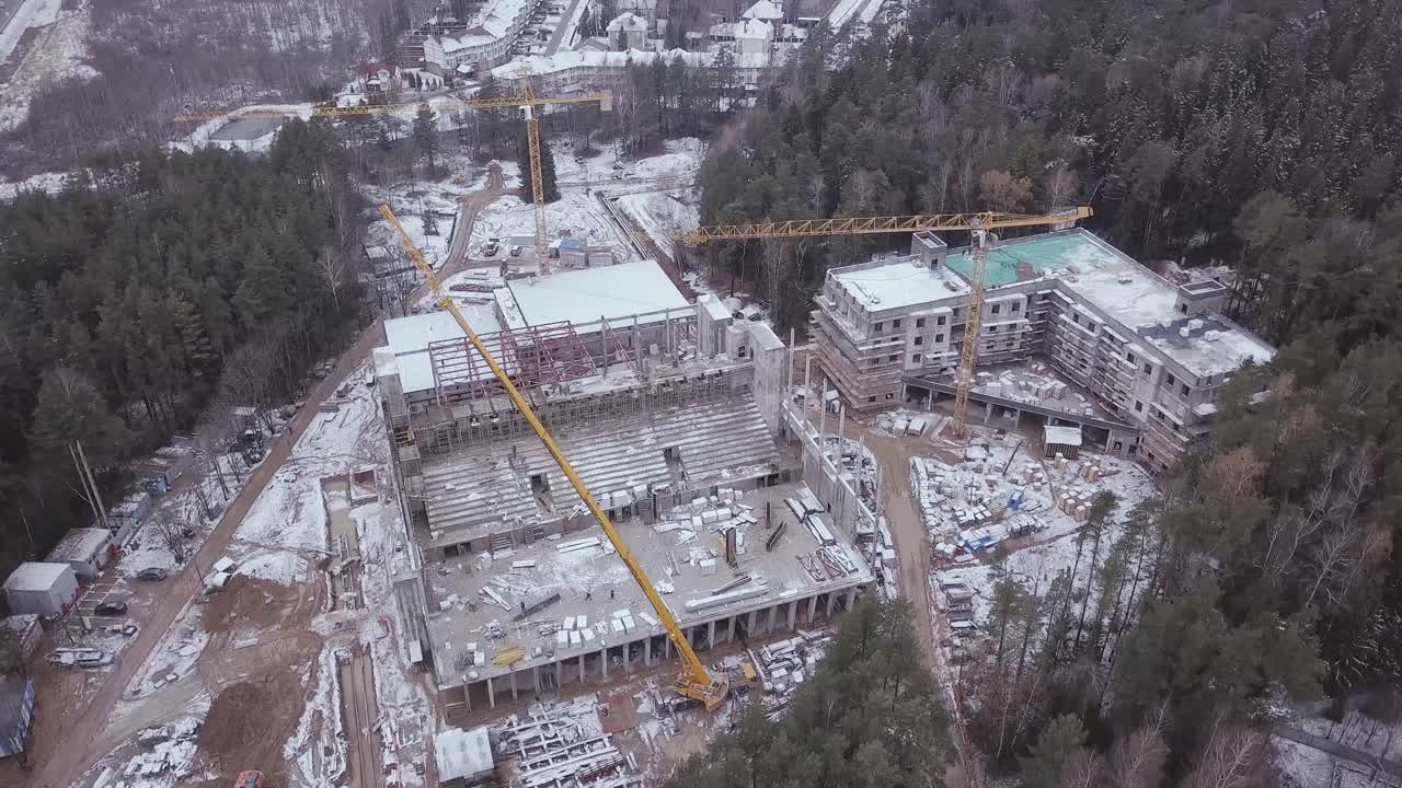 vista aérea del sitio de construcción con estadios y edificios residenciales en invierno