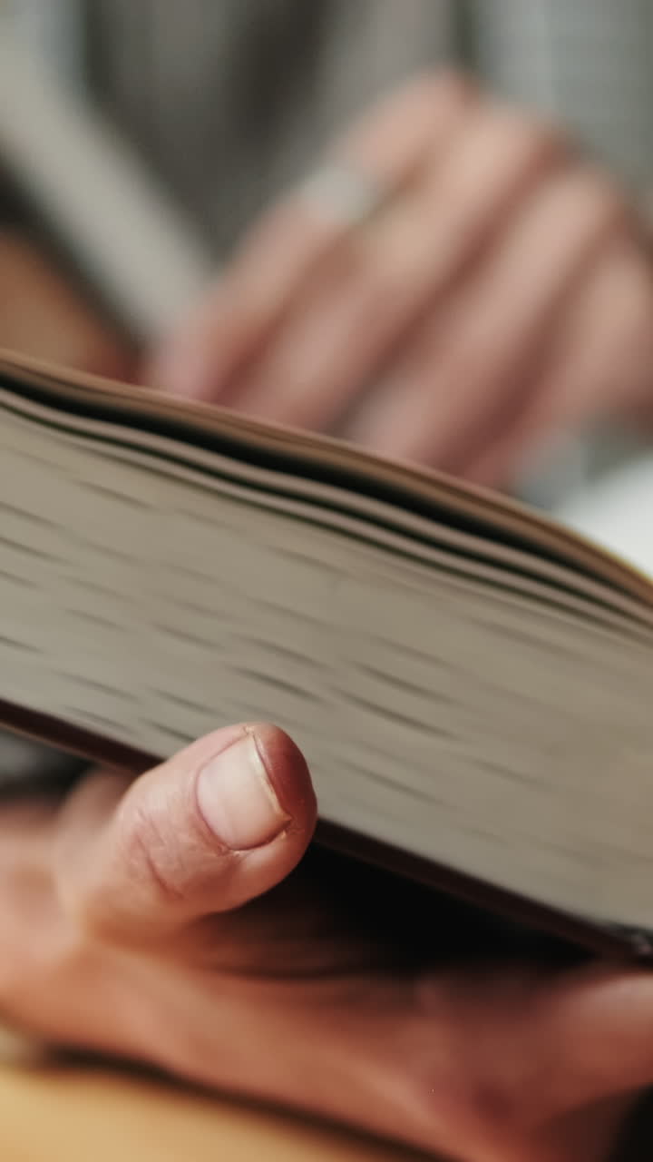 Close-up of a Person's Hands Turning Pages of a Book