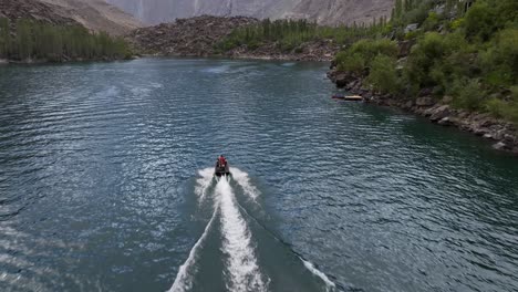 Aerial-View-Of-Jet-ski-Going-Across-Upper-Kachura-Lake-Skardu-With-Mountain-Landscape-In-Distance