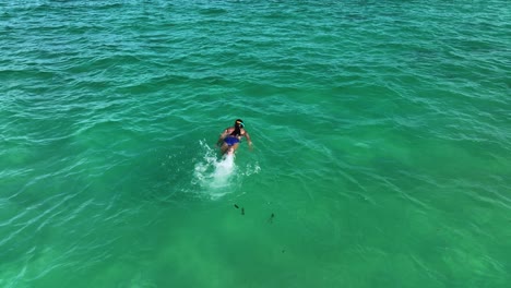 Luftaufnahme-Eines-Mädchens,-Das-Im-Türkisfarbenen-Wasser-Der-Karibik-Schwimmt-Und-Schnorchelt