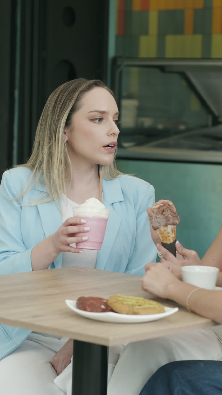 Wide shot of a group of friends chatting animatedly at an ice cream shop. A relaxed, youthful, and authentic scene that conveys friendship, connection, and enjoyment.