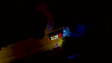 fire truck with emergency lights on the small street at night time. fire engine at scene of accident responds to emergency call. aerial shot