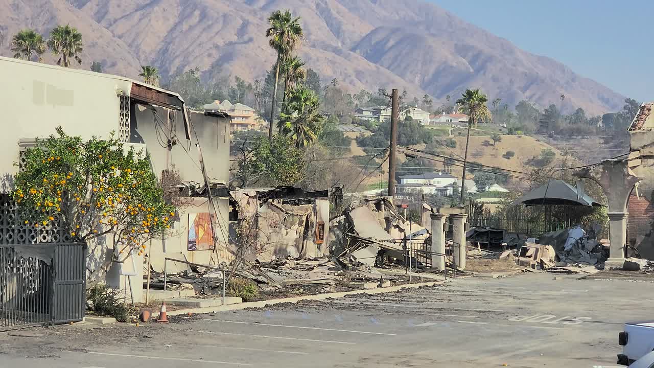 Charred urban ruins and hillside backdrop show wildfire damage, Los Angeles area