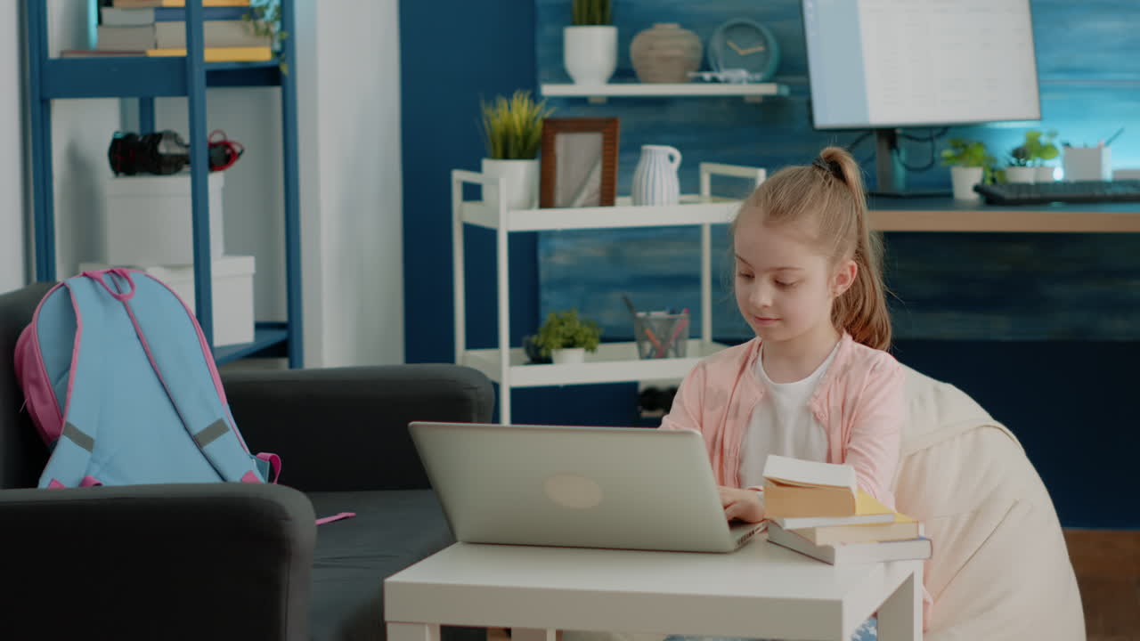 Little child using laptop for online school classes at home