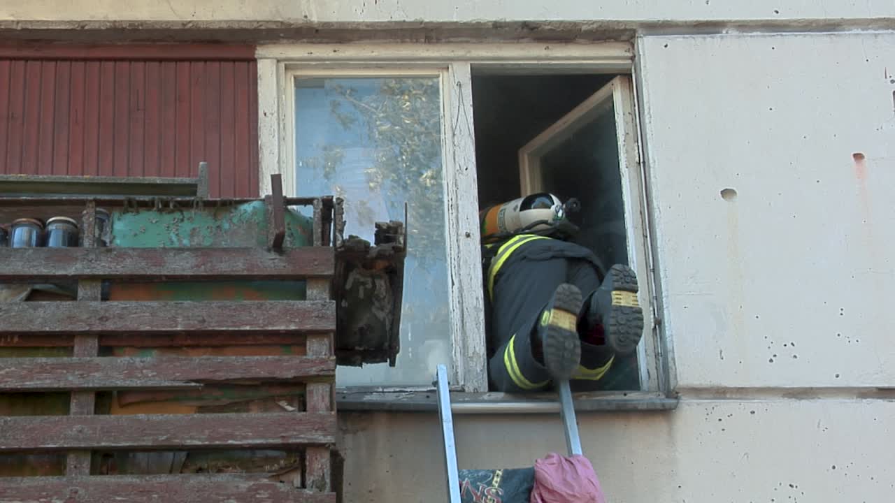 bombero trepa por la ventana de un apartamento para salvar a la gente