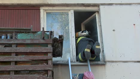 firefighter climbs up an apartment window to save people