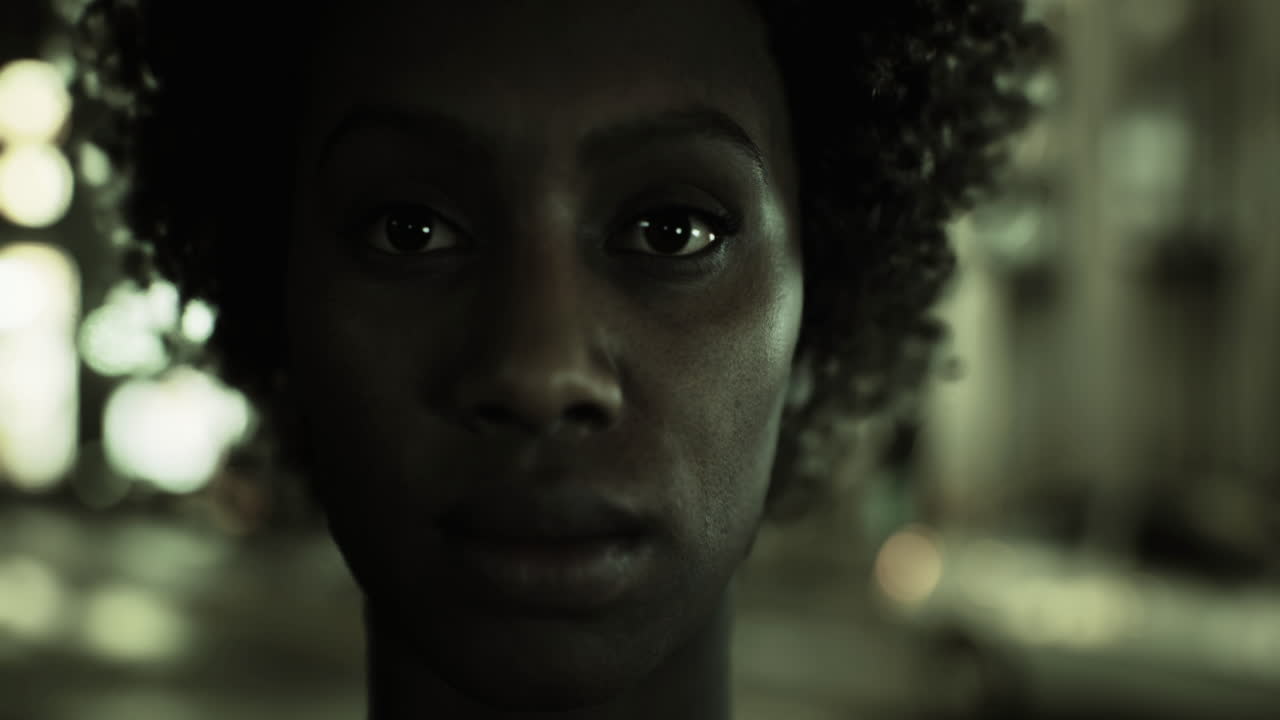 Intense close up of a person under city lights at night