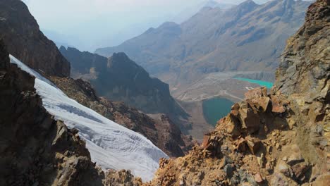 aerial shot rises over a rugged ridge to reveal a dramatic glacier valley and turquoise lakes near montaña mateo in the peruvian andes