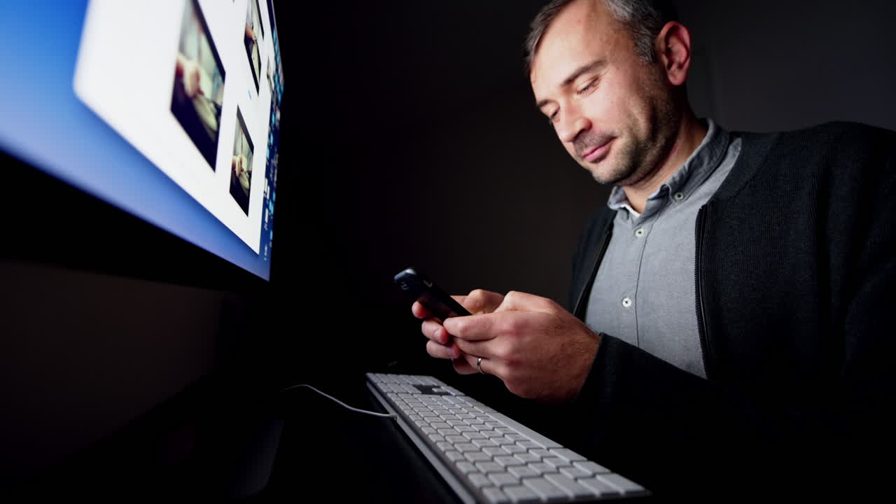 CHISINAU, MOLDAVIA - NOVEMBRE 2021: uomo che scrive un messaggio sul cellulare e ride di notte, in una stanza buia