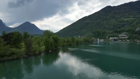 Serene-lake-aerial-view-with-calm-waters-and-mountain-Switzerland-backdrop